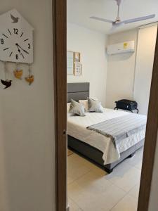 a bedroom with a bed and a clock on the wall at GabyMar salinas del mar Santamarta in Santa Marta +20 photos