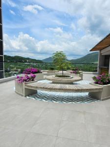 a patio with a fountain with a tree and flowers at GabyMar salinas del mar Santamarta in Santa Marta