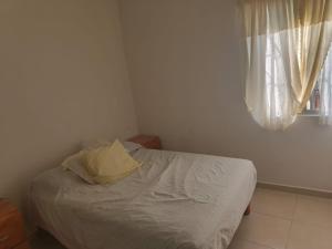 a small bed in a bedroom with a window at Casa Roque in El Balcón