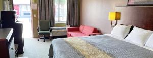 a hotel room with a bed and a red chair at Express Inn Thomson in Thomson