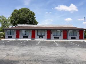 a building with red doors in a parking lot at Express Inn Thomson in Thomson