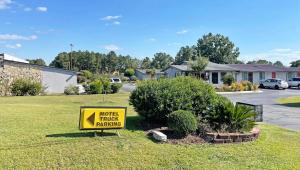 a yellow sign sitting in the grass in a yard at Express Inn Thomson in Thomson