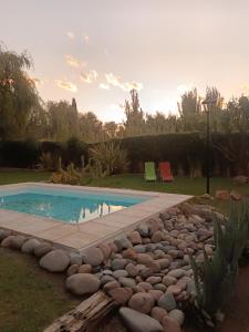 a swimming pool with rocks around it in a yard at Casa Darragueira de Chacras de Coria in Chacras de Coria