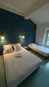 a bedroom with two beds and a blue wall at Hotel - Bar - LES PASSIONS in Buis-les-Baronnies
