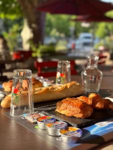 a table with bread and pastries and glasses on it at Hotel - Bar - LES PASSIONS in Buis-les-Baronnies