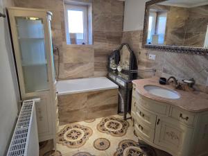 a bathroom with a sink and a tub and a shower at R Limoli Cozy in Trávnica +22 photos