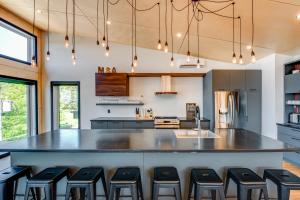 a kitchen with a large counter with black stools at Jackson 8 - 5 chambres - 18 personnes in Saint-Férréol-les-Neiges