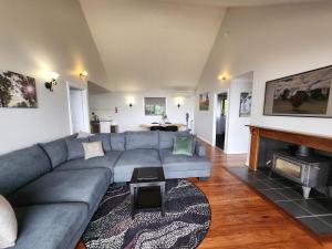 a living room with a couch and a fireplace at Scarlet Woods Chalets in Quinninup