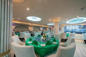 a dining room with a green table and chairs at فندق نايل ستوري سوهاج in Sūhāj