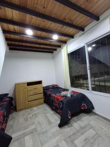 a bedroom with two beds and a dresser and a window at Casa con Piscina -El nogal in Las Heras