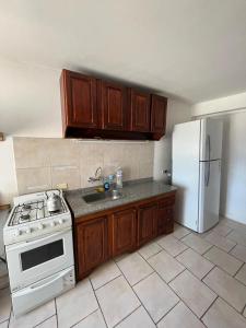 a kitchen with a stove and a white refrigerator at Hospedaje Buen Descanso in Paso de los Libres