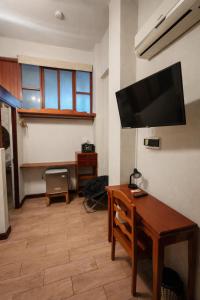 ein Wohnzimmer mit Schreibtisch und Flachbildfernseher in der Unterkunft Epoca Iquitos in Iquitos