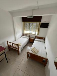 a bedroom with two beds and a window at Hospedaje Buen Descanso in Paso de los Libres