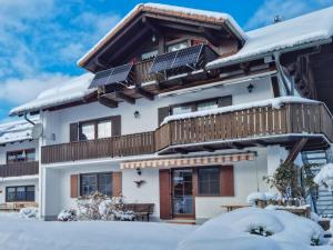 ein Haus mit Solarpaneelen auf dem Dach im Schnee in der Unterkunft Oachkatzl in Wildsteig