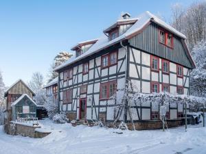 a large white and red house in the snow at Kaffeemühle Hamma II in Heringen
