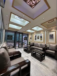 a waiting room with couches and tables and windows at Diamond Ridge Living 1RK G-02 in Haidar Sāhibgūda