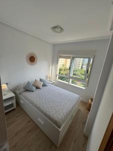 a white bedroom with a bed and a window at Sunny Escape in El Campello in El Campello +24 photos