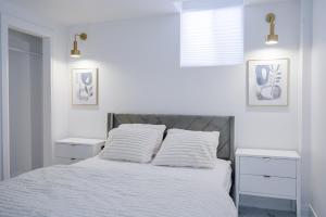 a white bedroom with a bed with two night stands at Bright Modern 1BR Suite Free Parking Fast WiFi Self Check-In in Bowmanville