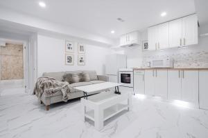 a white living room with a couch and a kitchen at Bright Modern 1BR Suite Free Parking Fast WiFi Self Check-In in Bowmanville