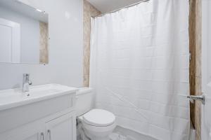 a white bathroom with a toilet and a sink at Bright Modern 1BR Suite Free Parking Fast WiFi Self Check-In in Bowmanville