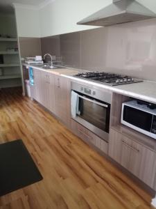 a kitchen with stainless steel appliances and wooden floors at Lakeside view in Cuthbert