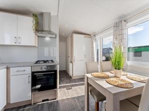 a kitchen and dining room with a table and chairs at Comfortable mobile home in Middelkerke in Middelkerke +8 photos