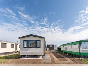 a tiny house is parked next to a train at Comfortable mobile home in Middelkerke in Middelkerke