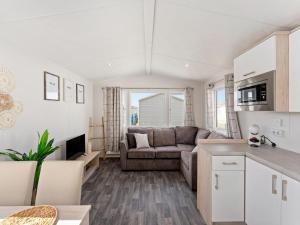 a living room with a couch and a table at Comfortable mobile home in Middelkerke in Middelkerke