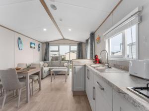 a kitchen and living room with a table and a couch at Chalet in De Haan with terrace in De Haan