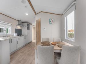 a kitchen and dining room with a table and chairs at Chalet in De Haan with terrace in De Haan +8 photos