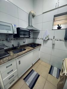a small kitchen with a sink and a stove at Palácio Quitandinha in Petrópolis