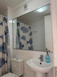 a bathroom with a sink and a toilet and a mirror at Departamento frente a la playa in Arica +27 photos