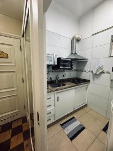 a small kitchen with a sink and a microwave at Palácio Quitandinha in Petrópolis +11 photos