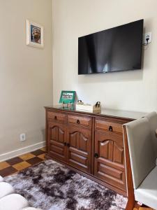 a living room with a television on a wall at Palácio Quitandinha in Petrópolis