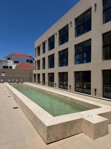 a swimming pool in front of a building at Nogales Apartamentos in Mar del Plata