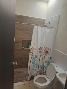 a bathroom with a toilet and a shower curtain at Casa Roque in El Balcón