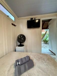 a bedroom with a bed with a television on the wall at Pousadinha in Ilha do Mel