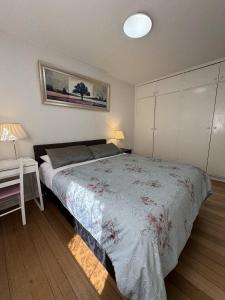 a bedroom with a bed and a table with a lamp at Knightsbridge Apartments in Melbourne