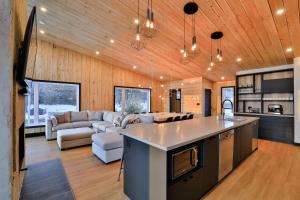 a kitchen and living room with a couch and a table at Aspen - 5 chambres - 18 personnes in Saint-Férréol-les-Neiges