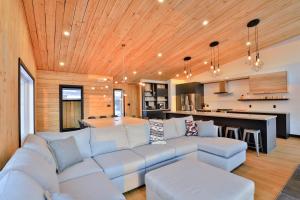 a living room with a couch and a kitchen at Aspen - 5 chambres - 18 personnes in Saint-Férréol-les-Neiges