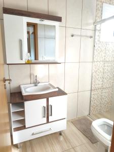 a bathroom with a sink and a shower at Beach house - Praia Recreio Torres in Torres +68 photos
