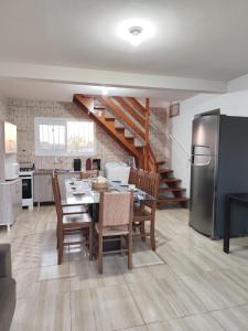 a kitchen and dining room with a table and a refrigerator at Beach house - Praia Recreio Torres in Torres