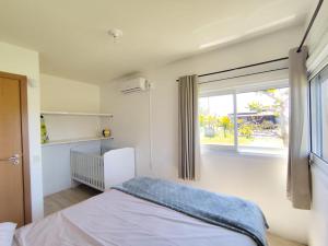 a bedroom with a bed and a window at Beach house - Praia Recreio Torres in Torres