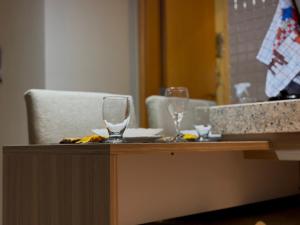 two wine glasses sitting on top of a counter at Flat com Ar, Piscina, Garagem, Cozinha e Wi-Fi in Campo Grande