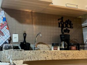 a kitchen counter with wine glasses on a counter top at Flat com Ar, Piscina, Garagem, Cozinha e Wi-Fi in Campo Grande +14 photos