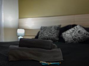 a pile of towels sitting on top of a bed at Flat com Ar, Piscina, Garagem, Cozinha e Wi-Fi in Campo Grande