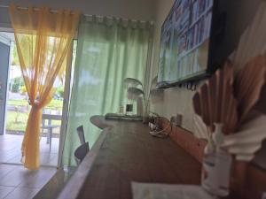 a room with a table and a green curtain at Studio Hamaca112 à Marie-Galante in Folle Anse