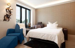 a bedroom with a bed and a blue chair at Eden in Binz