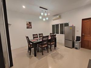 a dining room with a table and chairs and a refrigerator at Chotam House in Nathon Bay