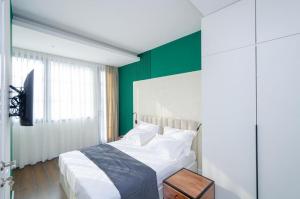 a bedroom with a bed with a green wall at Mashtots Avenue 31 in Yerevan